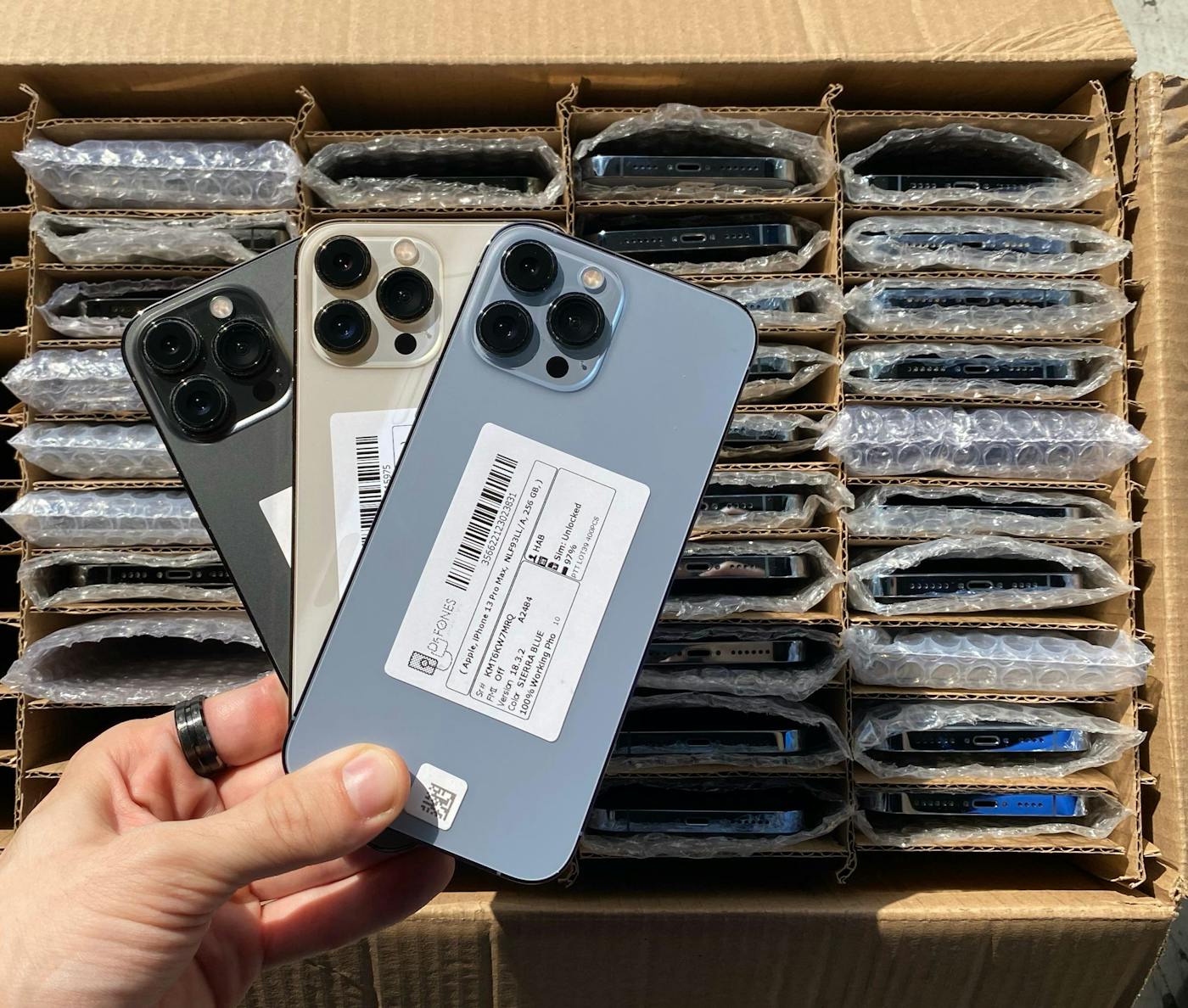 A batch of smartphones in a box ready for wholesale inspection.